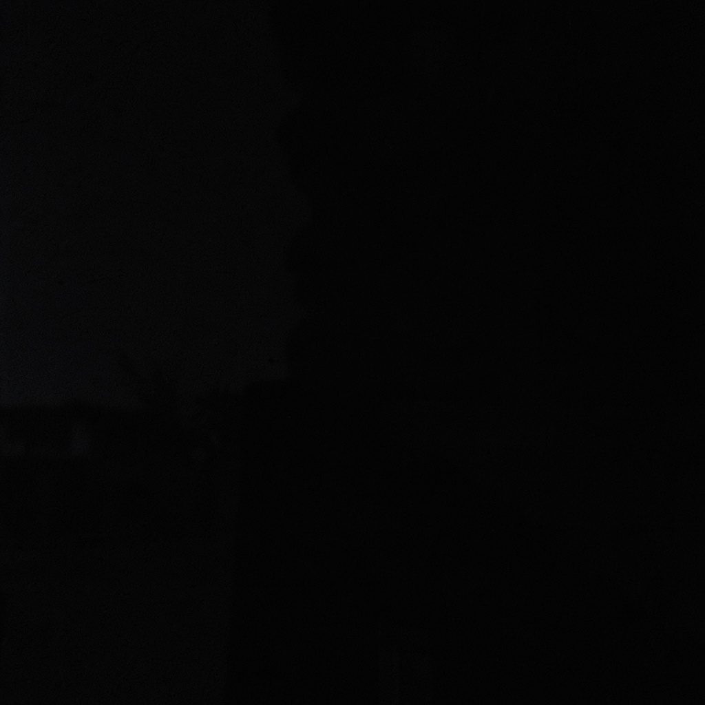 A softly lit registration desk with a clipboard and pen, warm amber tones against deep shadow